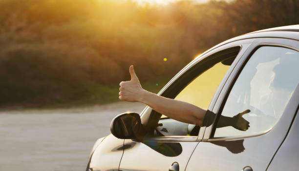 man giving thumbs up inside the car
